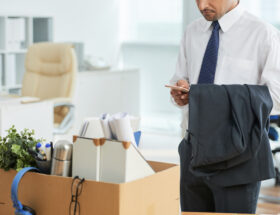 Man som packat ner lådor i kontor