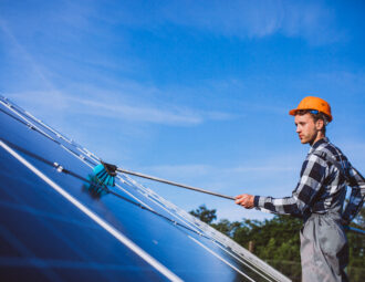 Man som tvättar solpaneler på tak